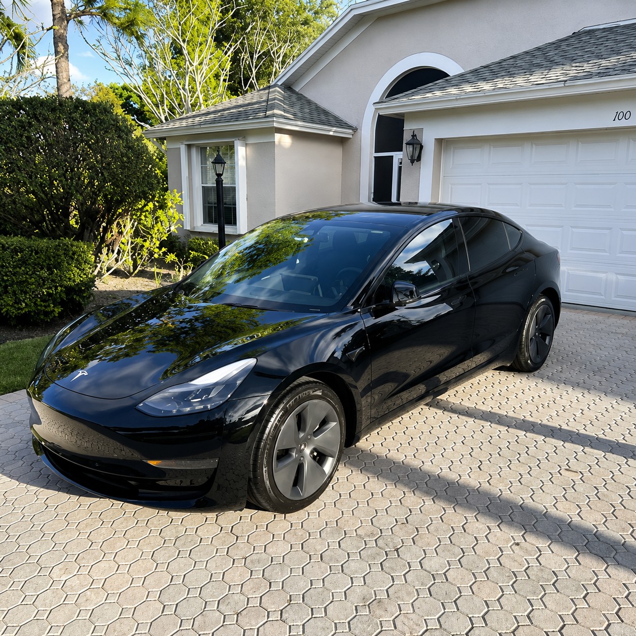 Freshly detailed black sedan parked in a driveway